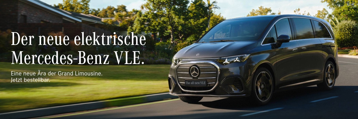 Vollelektrischer Mercedes-Benz VLE fährt auf einer Straße durch eine grüne Wohngegend, Frontansicht in Bewegung bei Tageslicht.